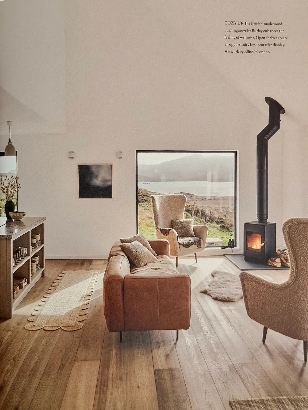 Minimal white living room with a leather sofa, wood stove and a picture window