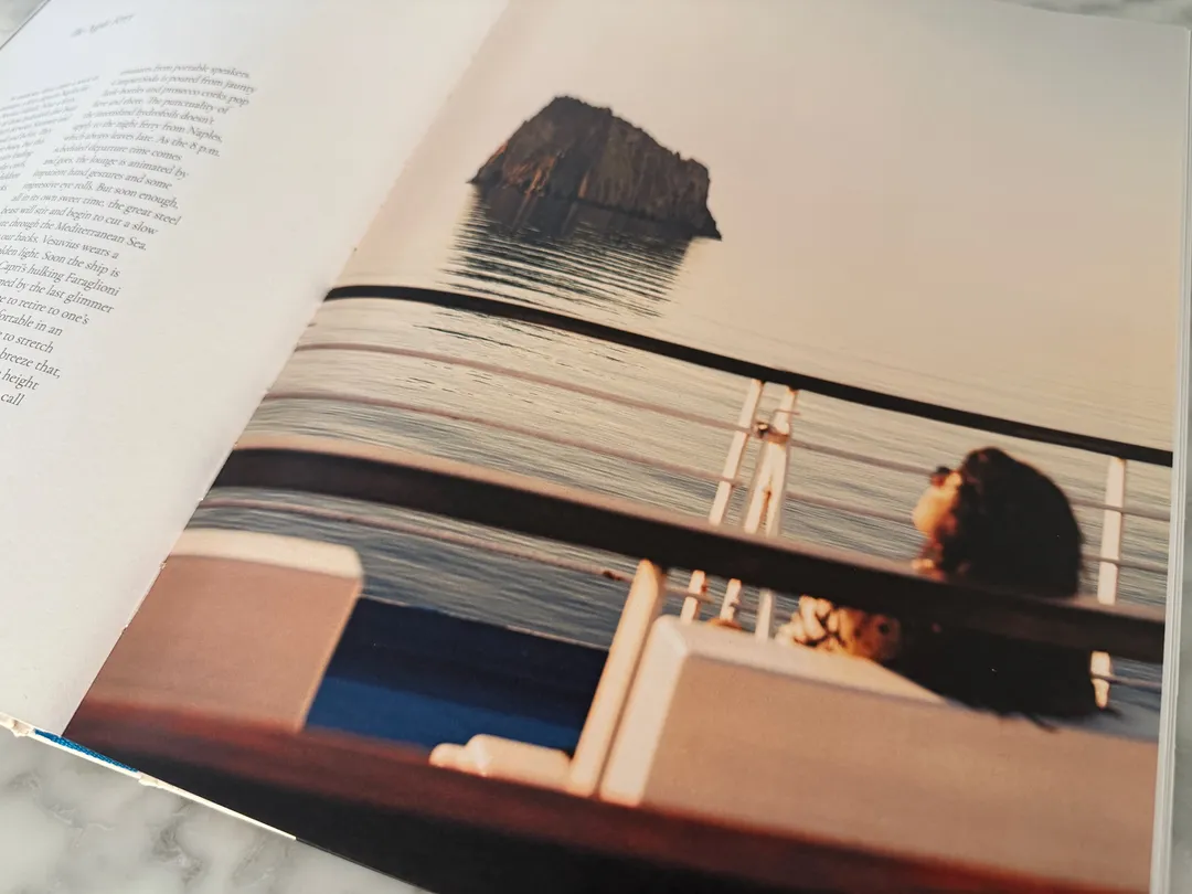 Woman at a ferry window passing a rocky islet