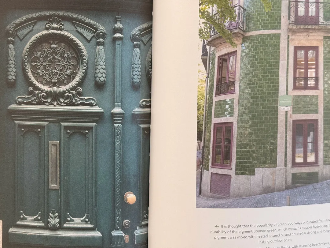 Ornate teal front door, and a building clad in green tiles