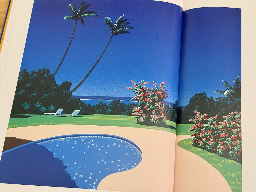 Kidney-shaped pool on a lawn with palms and flowering bushes