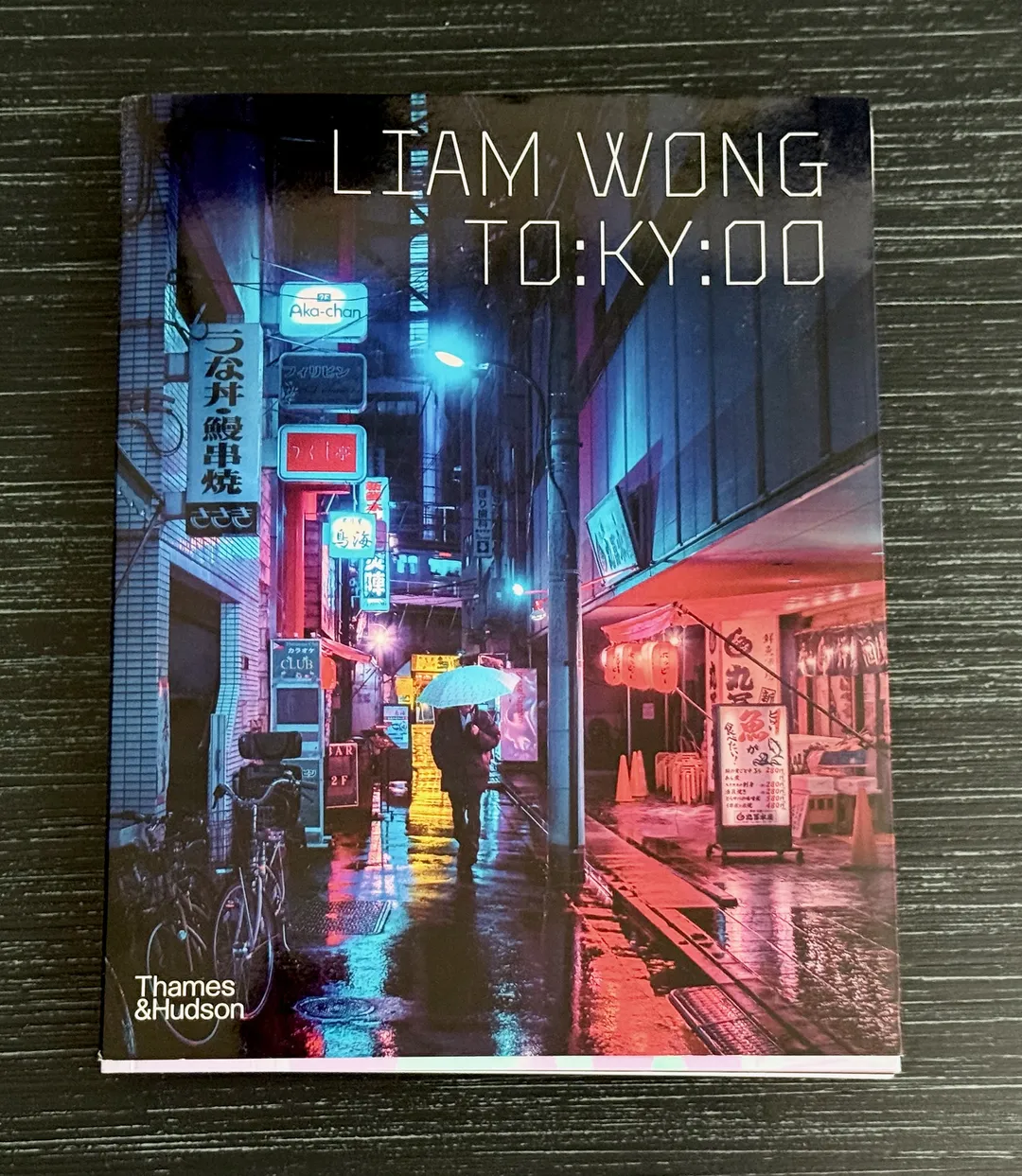 TO:KY:OO by Liam Wong, cover of a rainy neon alley in Tokyo