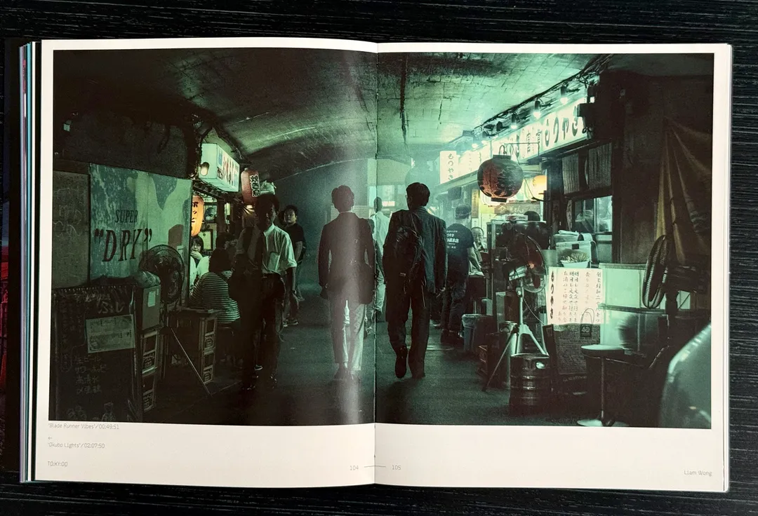 Shoppers in a dim, green-lit covered market street