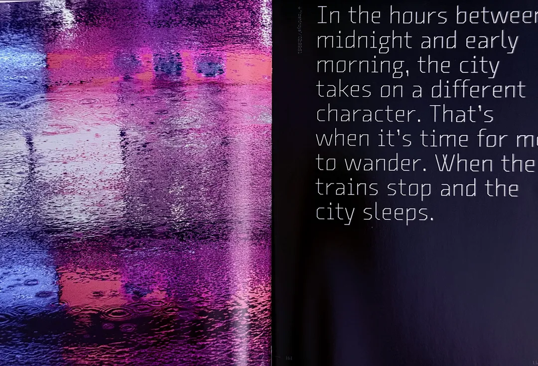 Purple reflections on wet pavement beside a quote about the city at night