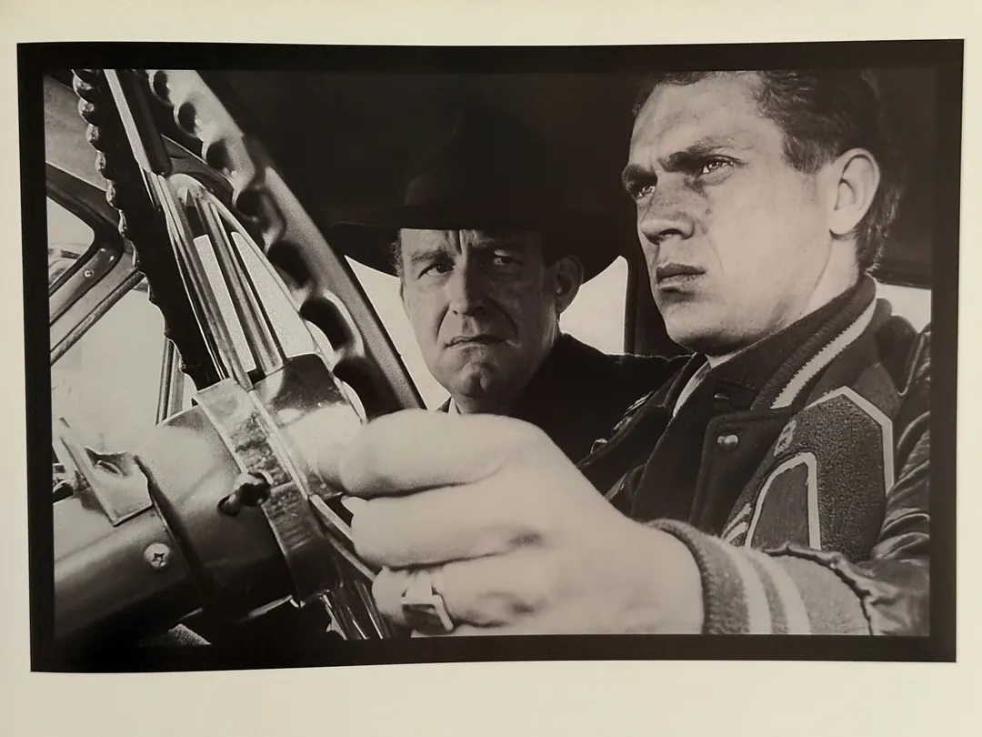Steve McQueen loading a rifle in a black-and-white film still