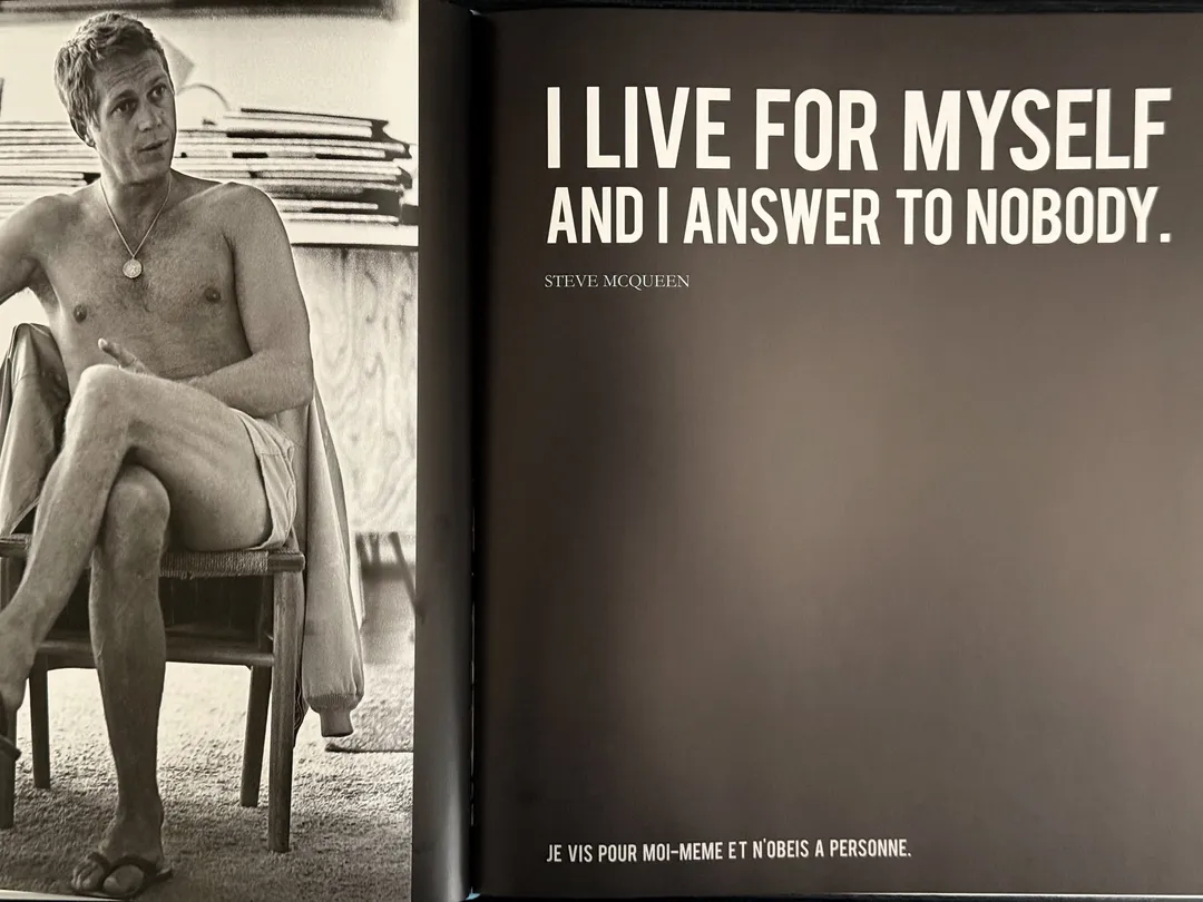 McQueen seated in shorts opposite the quote 'I live for myself and I answer to nobody'