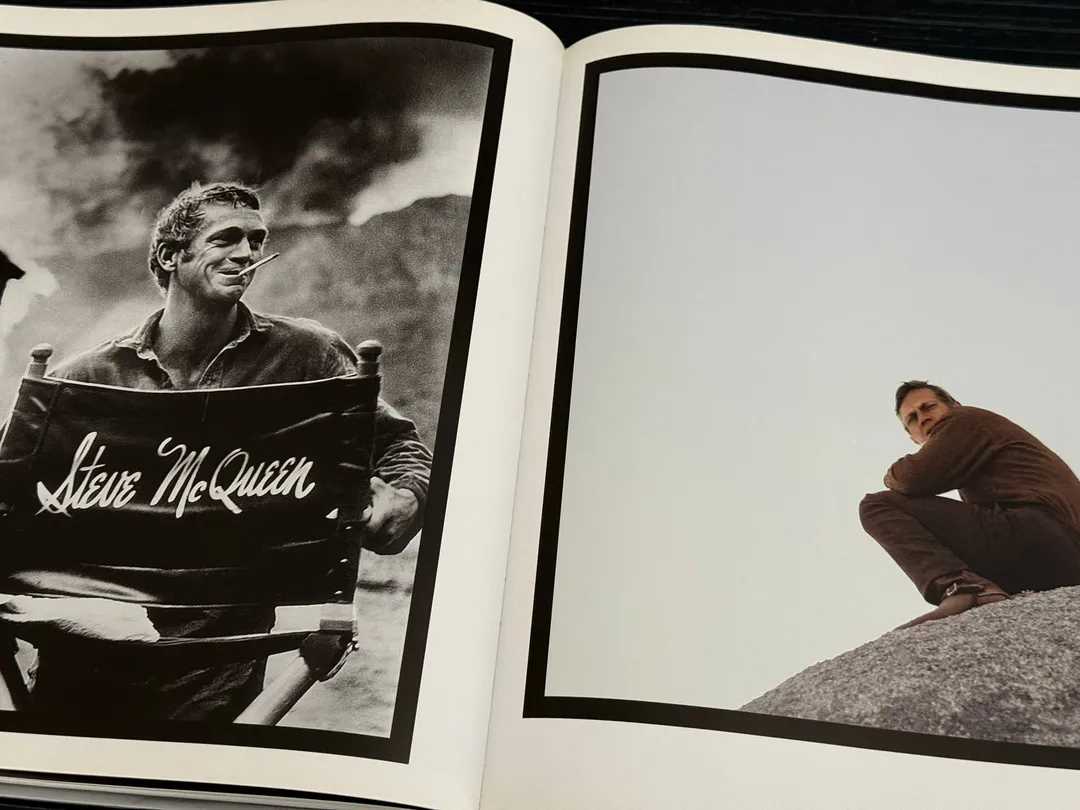 McQueen holding his director's chair, and sitting on a rock
