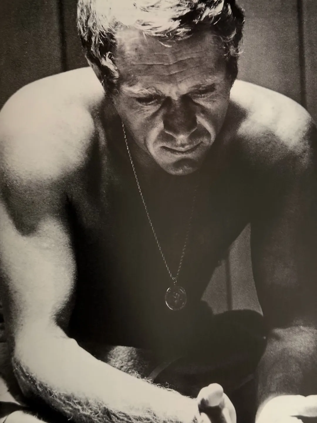 Black-and-white portrait of Steve McQueen, shirtless and pensive, from Unforgettable Steve McQueen
